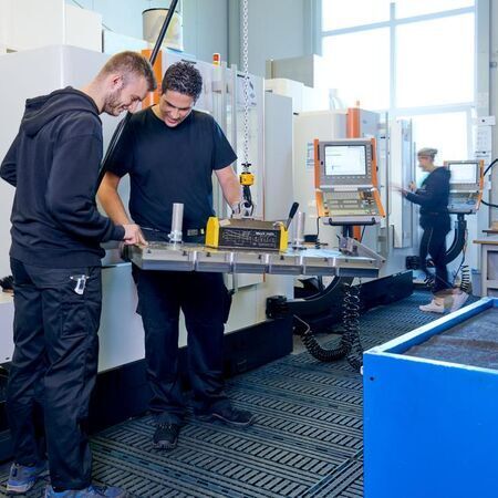 Zwei Techniker arbeiten an einer Maschine in einer modernen Werkstatt