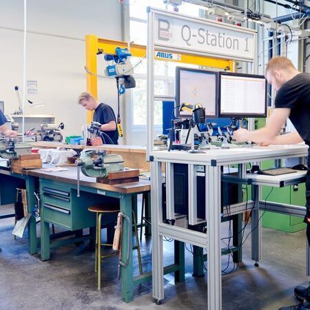 Mitarbeiter arbeiten in einer modernen Werkstatt an Maschinen