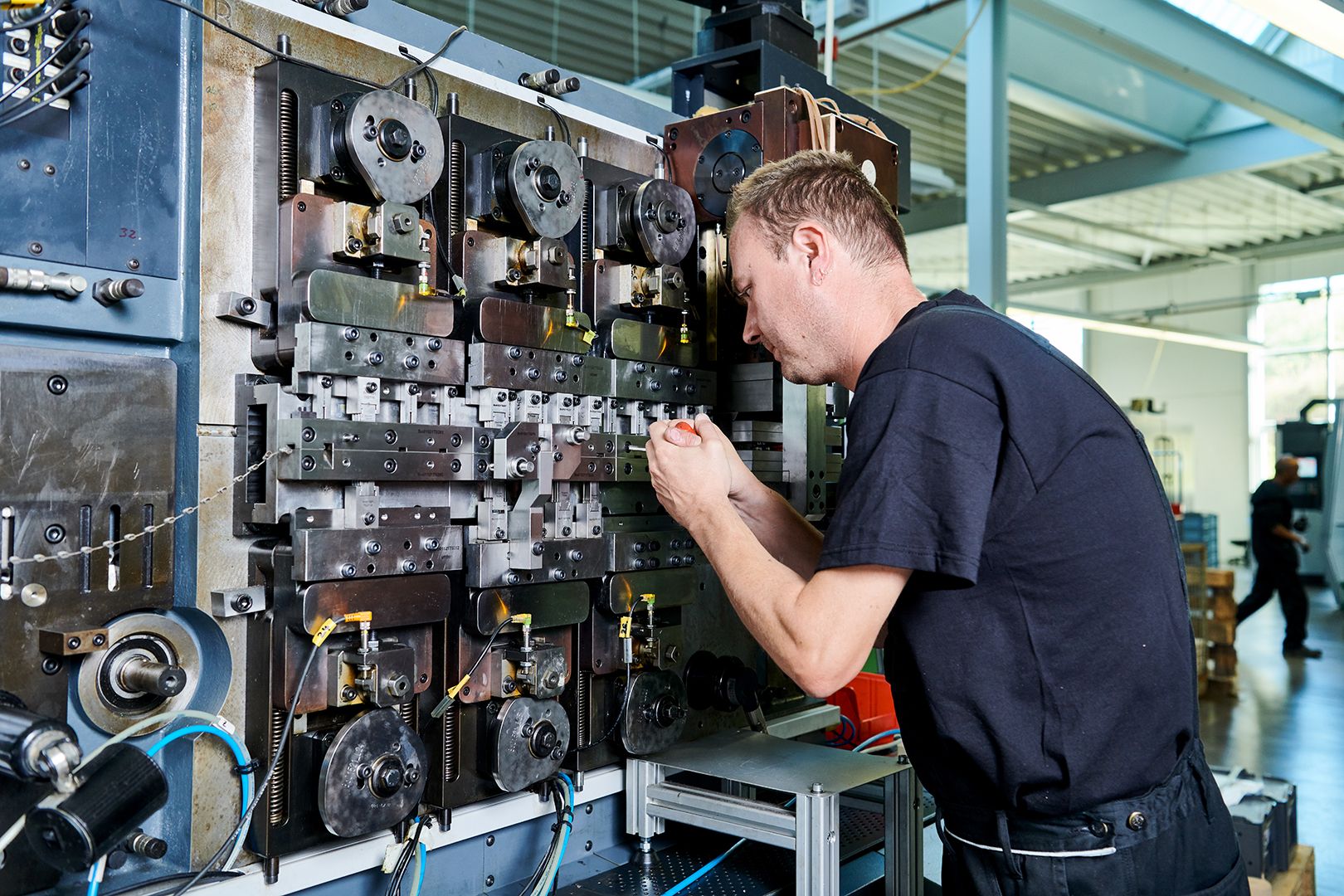 A technician working on stamping technology machinery